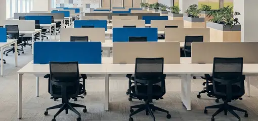 Modern open-plan office space featuring clean workstations, ergonomic chairs, and sanitized carpets provided by professional office cleaning services in Grand Rapids, MI.